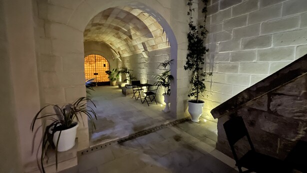An interior with stone arches, potted plants, and a staircase. - Dimora Assuntina Fine Rooms (Martano)