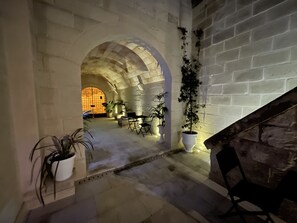 An interior with stone arches, potted plants, and a staircase. - Dimora Assuntina Fine Rooms (Martano)