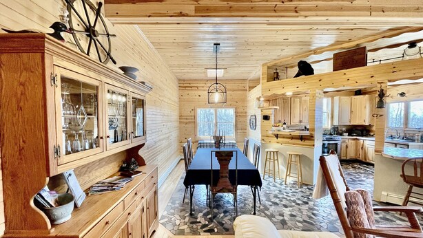 Un interior espacioso de madera con comedor, cocina y una zona de estar acogedora.