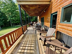 A wooden deck with outdoor seating and a covered area.