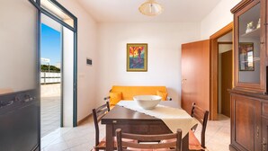 A dining area with a table, chairs, a bowl, a painting, and a cabinet. - Villa Lucia - Bilo 2 by BarbarHouse (Boncore)