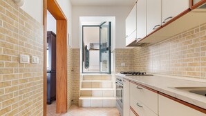 A kitchen with a brick wall, a wooden door, a window, and a sink. - Villa Lucia - Bilo 2 by BarbarHouse (Boncore)