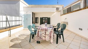A rooftop patio with a table set for four, surrounded by chairs, under a clear sky. - Villa Lucia - Bilo 2 by BarbarHouse (Boncore)