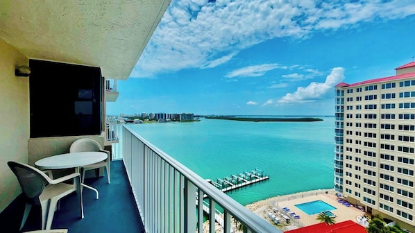 A balcony with a view of a marina and a pool area.