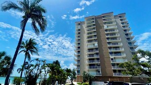 A high-rise hotel with multiple balconies, a beach view, and palm trees. - Lovers Key Beach Club 1105 - Private Beach (Bonita Springs)