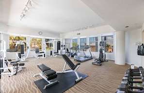 A gym with various exercise equipment, including treadmills, weight machines, and benches. - Southern Comfort - Updated Waterfront Condo (Bonita Springs)