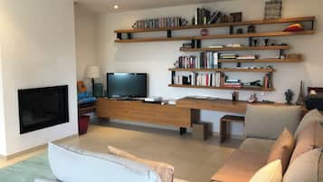 TV connectée, cheminée, table de tennis de table, livres