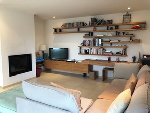 TV connectée, cheminée, table de tennis de table, livres