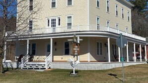 A two-story building with a covered front porch and a sign indicating it is a museum. - Apt 3A Lake Bomoseen Inn “The Dog” with boat slip. (Castleton)