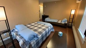A small, compact room with two beds, a desk, and a standing lamp. - Apt 3A Lake Bomoseen Inn “The Dog” with boat slip. (Castleton)