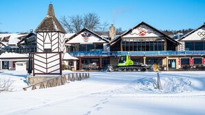 Een hotel met een skilift, een overdekt buitengedeelte en een gebouw met een ski-vlag.