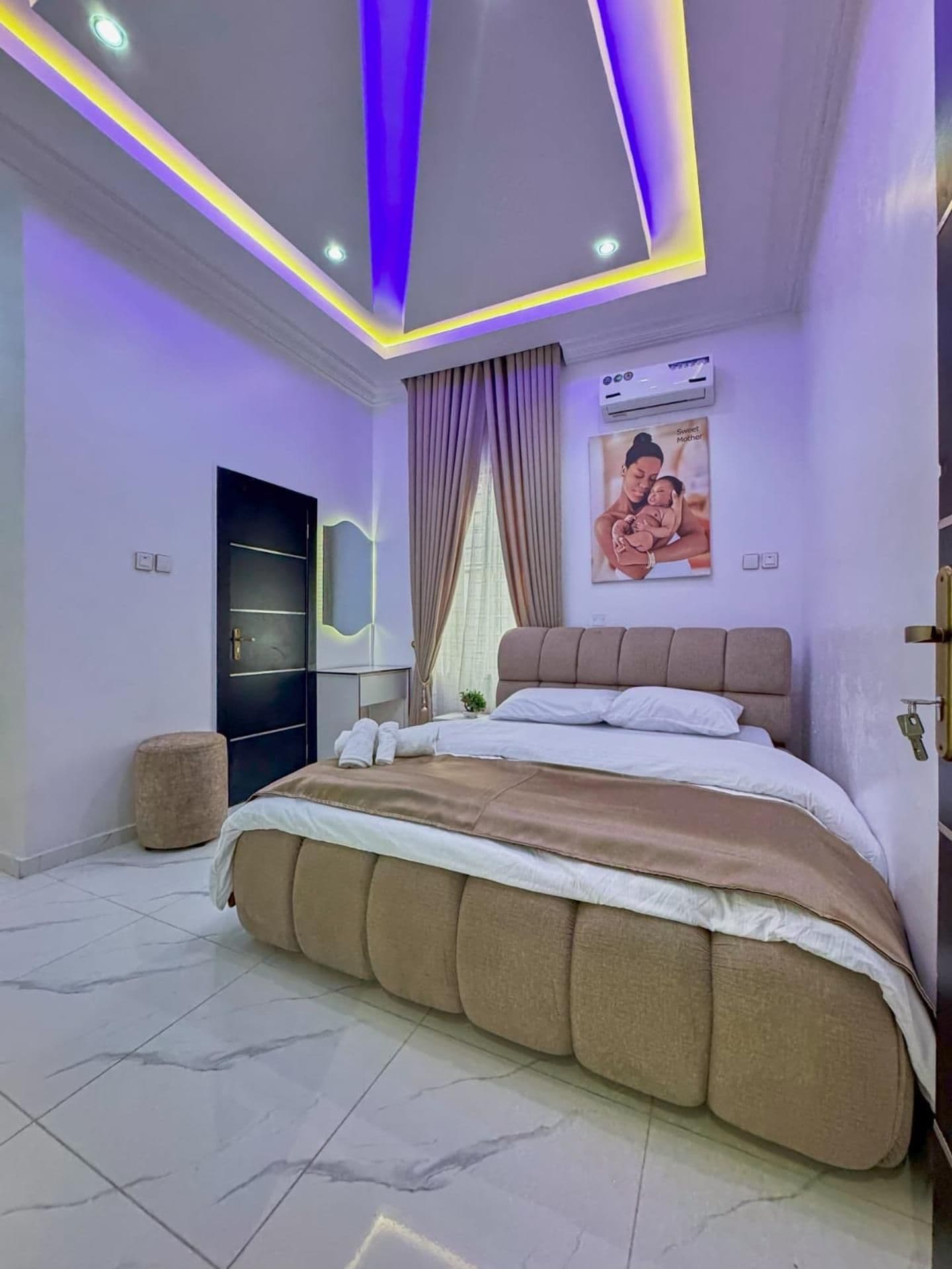 Een moderne slaapkamer met een groot bed, een kledingkast en een plafond met LED-verlichting.