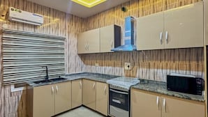 A modern kitchen with built-in cabinets, a microwave, and a dishwasher. - 1 Bedroom Ensuite in a Shared House (Lekki)