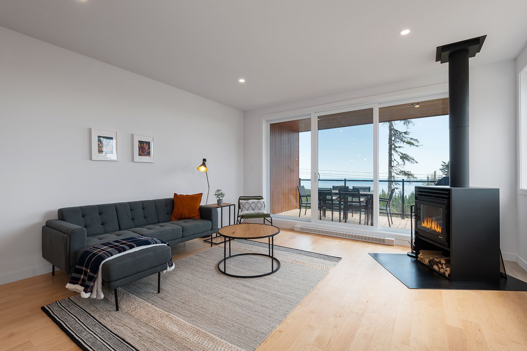 Una sala moderna con un sofá, una mesita redonda y una chimenea.