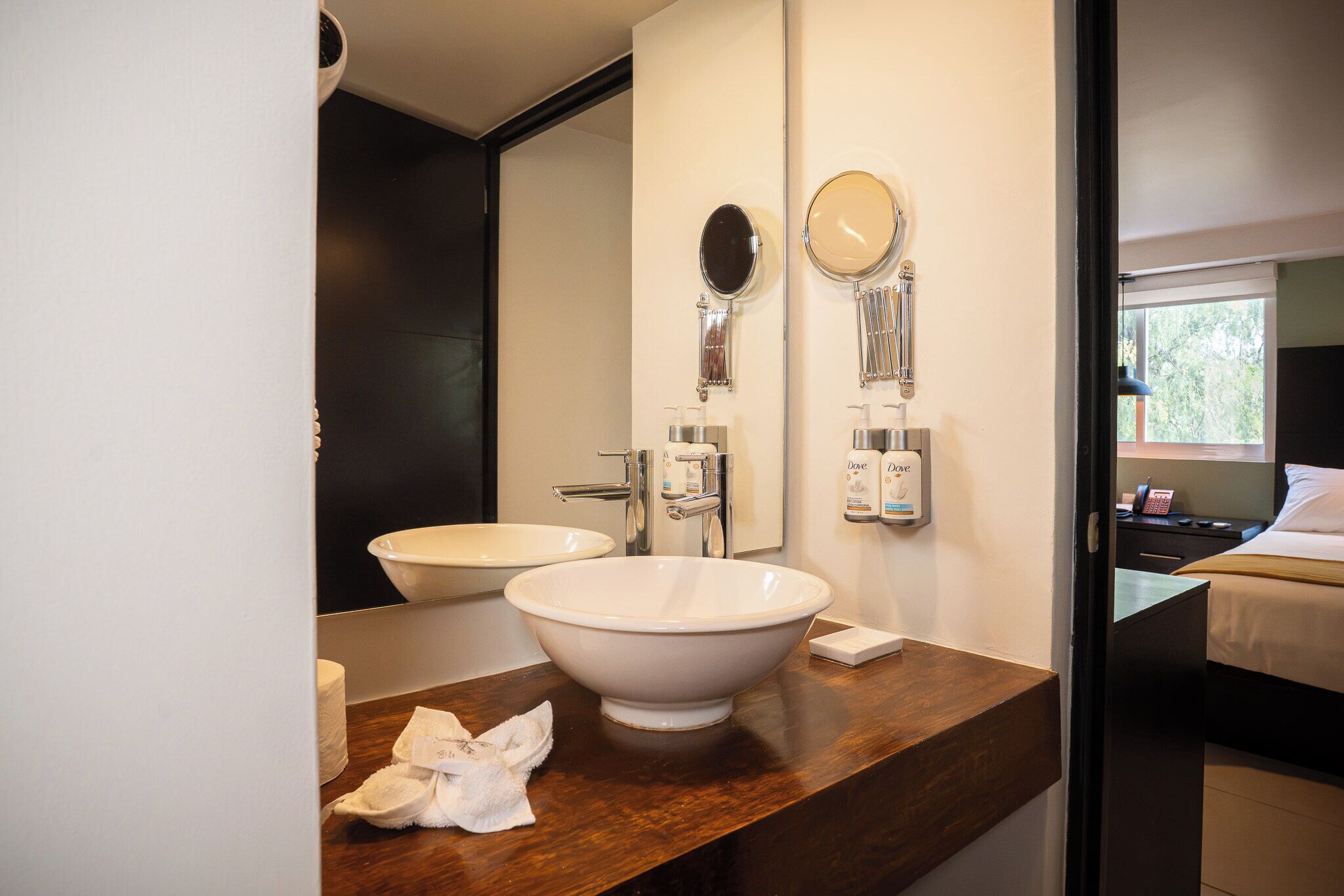 Un baño con un lavamanos grande blanco, un espejo y un inodoro.