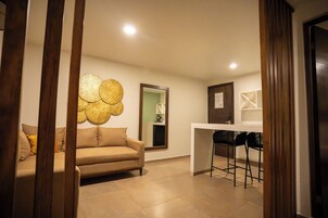 Una sala moderna con sofá, una mesa de centro y un comedor con sillas.