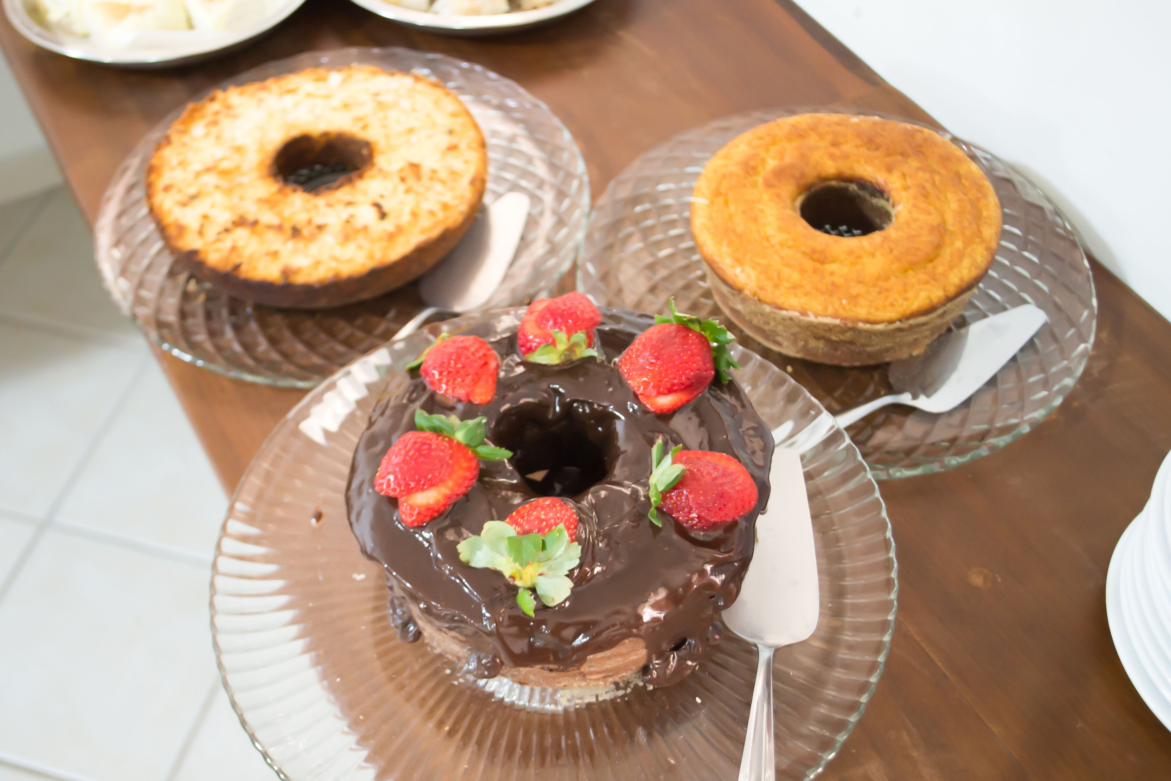 A chocolate cake with strawberries on a glass plate.