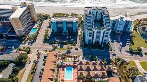 A coastal hotel with multiple high-rise buildings, a swimming pool, and a star symbol indicating a star rating. - The Bungalow, 2nd row from Ocean, Pool/Hot Tub! (Myrtle Beach)