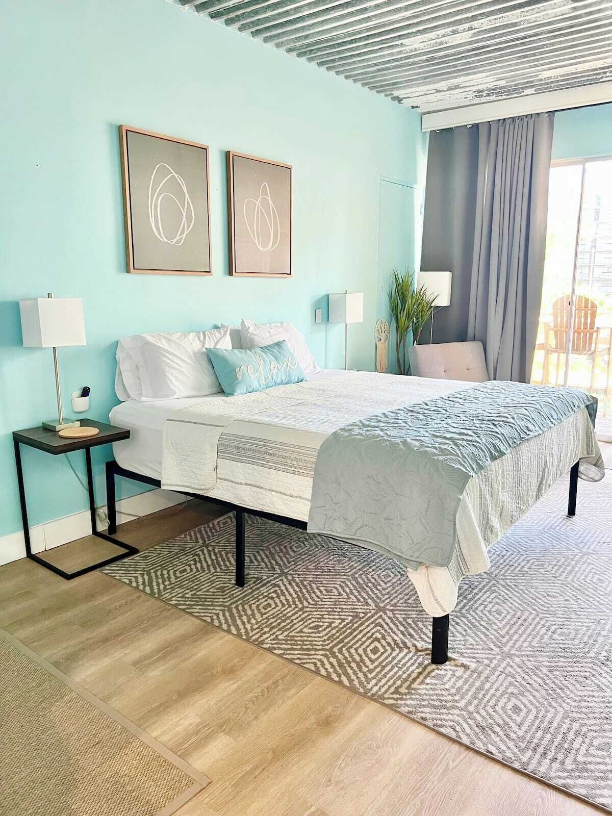 Ein Schlafzimmer mit einem Bett, Nachttischen, einem Teppich und Bildern an der Wand.