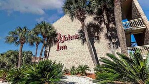 A building with 'John's Inn' signage, surrounded by palm trees. - The Bungalow, 2nd row from Ocean, Pool/Hot Tub! (Myrtle Beach)