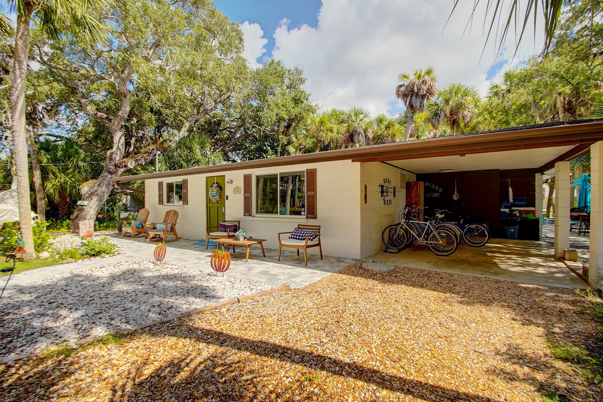A house with a covered porch, outdoor seating, and bicycles.