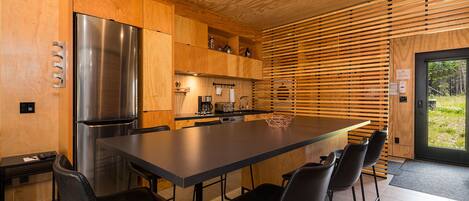 A modern kitchen with a large island, stainless steel appliances, and wooden cabinetry.