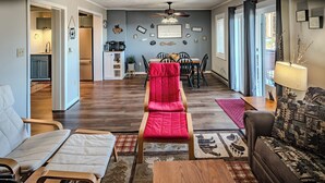 A living room with a sofa, a chair, a coffee table, and a dining area with a table and chairs.
