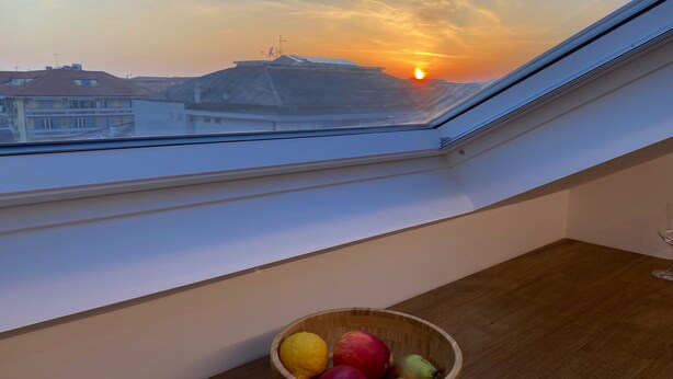 Vista desde una ventana con una mesa de madera y un frutero.
