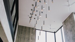 Et moderne interiør med store vinduer, højt til loftet og hængende pendellamper.