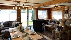 A cozy cabin interior with a dining area, a sofa, and a couch. - on gorgeous Great Pond (lake), great for families!  (Belgrade)