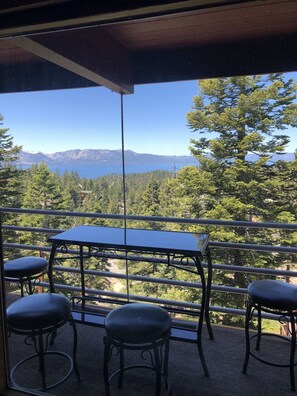Enjoy a serene view of the forest and lake from this outdoor balcony.