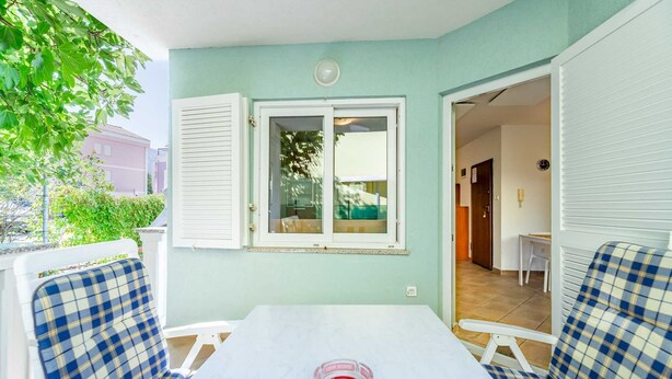 A room with a table, two chairs, a window, and a door leading to another room. - Ema - Cozy Pet-friendly Suite for Two with Parking (Baška)