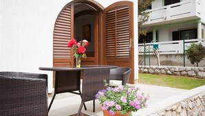 A patio with wicker furniture and a potted plant. - Apartment Bozo Baska on the ground floor with terrace (Baška)