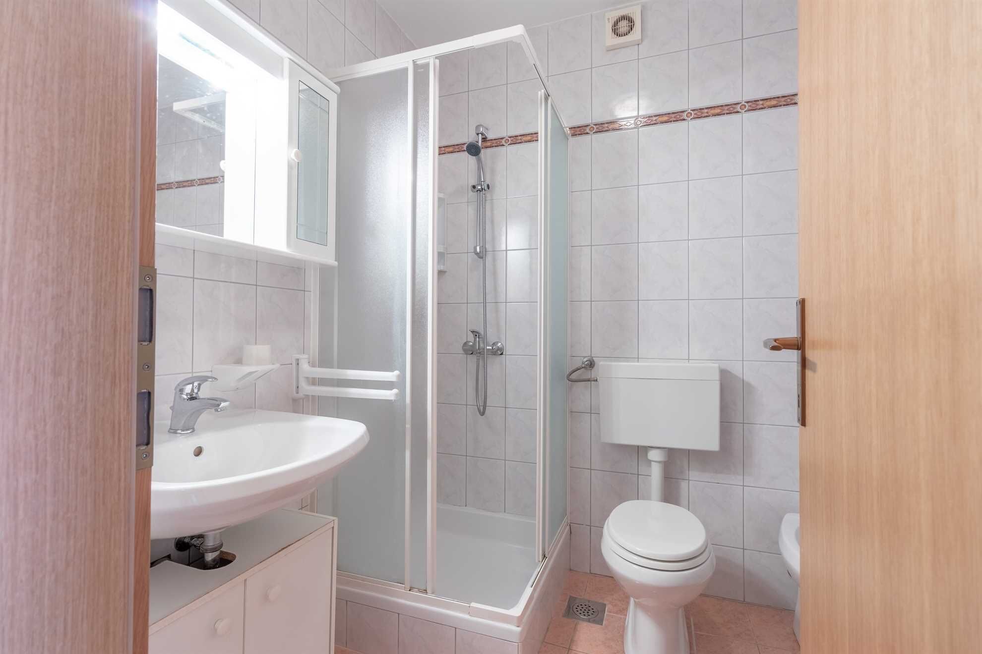 A bathroom with a shower, toilet, and sink.