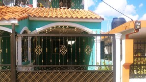 A gated entrance with ornate metalwork and a tiled roof. - Nido del patio, 40 min playa boca chica y 5 min centro de ciudad (Santo Domingo, Este)