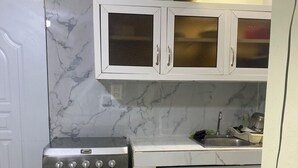A kitchen with a built-in oven, white cabinets, and a marble backsplash. - Nido del patio, 40 min playa boca chica y 5 min centro de ciudad (Santo Domingo, Este)