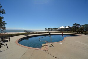 A swimming pool with a metal ladder, surrounded by a concrete deck, with a beach and ocean view in the background. - Coastal Living, beachfront complex, pool, new furniture!




Finance with Affirm (Dauphin Island)