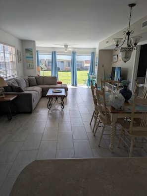 A living room with a sofa, coffee table, dining table with chairs, and a view of the backyard. - Coastal Living, beachfront complex, pool, new furniture!




Finance with Affirm (Dauphin Island)
