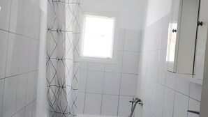 Un bagno moderno con un water, una vasca e un lavandino.