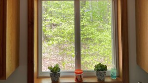 A kitchen with a window, wooden cabinets, and a wall sign stating "the secret ingredient is love." - STOP SCROLLING & CHECK OUT OUR REVIEWS. NO ADDITIONAL FEES TO ENTER COMMUNITY (Pocono lake)
