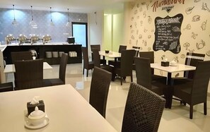 A restaurant interior with a bar area, dining tables, and chairs. - MJ s Hotel (Jambi)