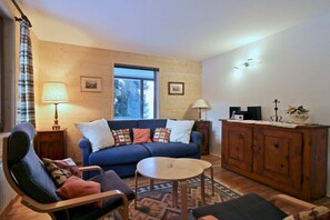 Departamento básico, varias camas | Sala de estar | Televisión, chimenea y estéreo