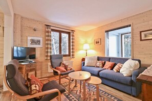 Departamento básico, varias camas | Sala de estar | Televisión, chimenea y estéreo