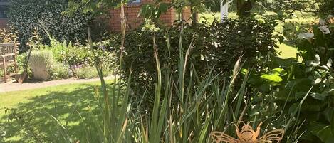 A garden with various plants and a wooden sculpture.