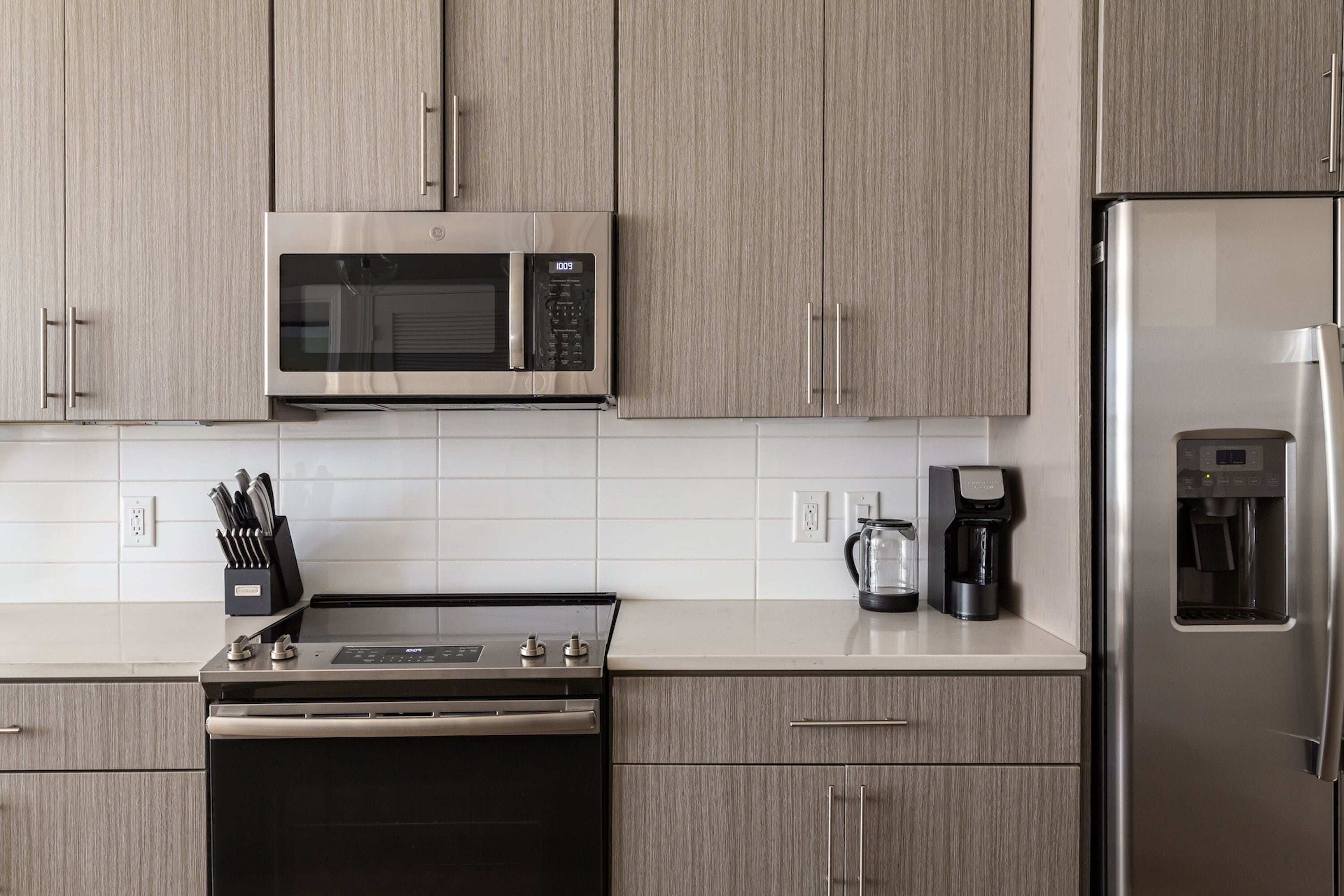 Una cucina moderna con elettrodomestici in acciaio inossidabile, mobili in legno e una macchina da caffè.