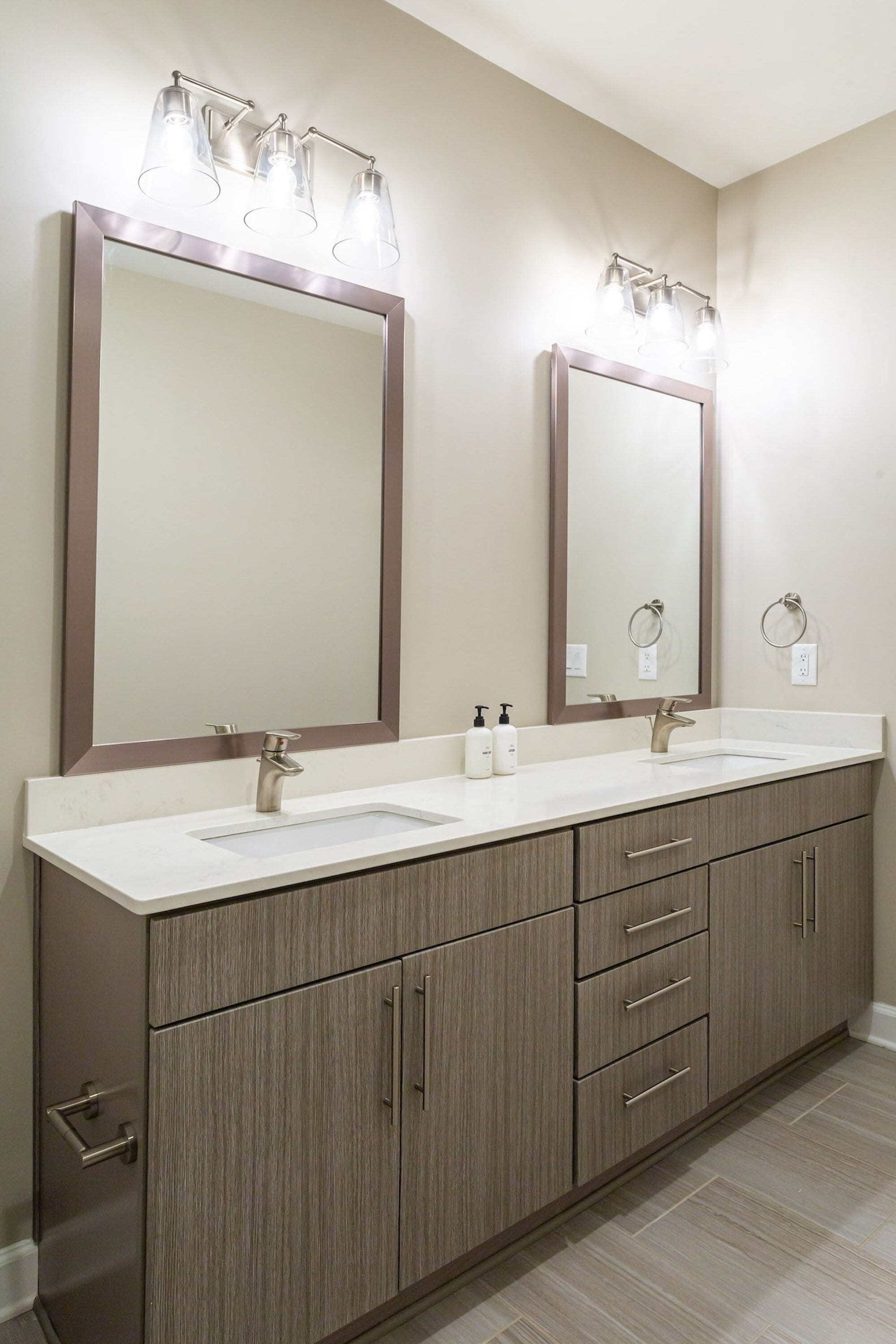 A bathroom with two sinks, a large mirror, and a vanity with drawers.