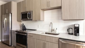 A modern kitchen with stainless steel appliances, a microwave, and a coffee maker.