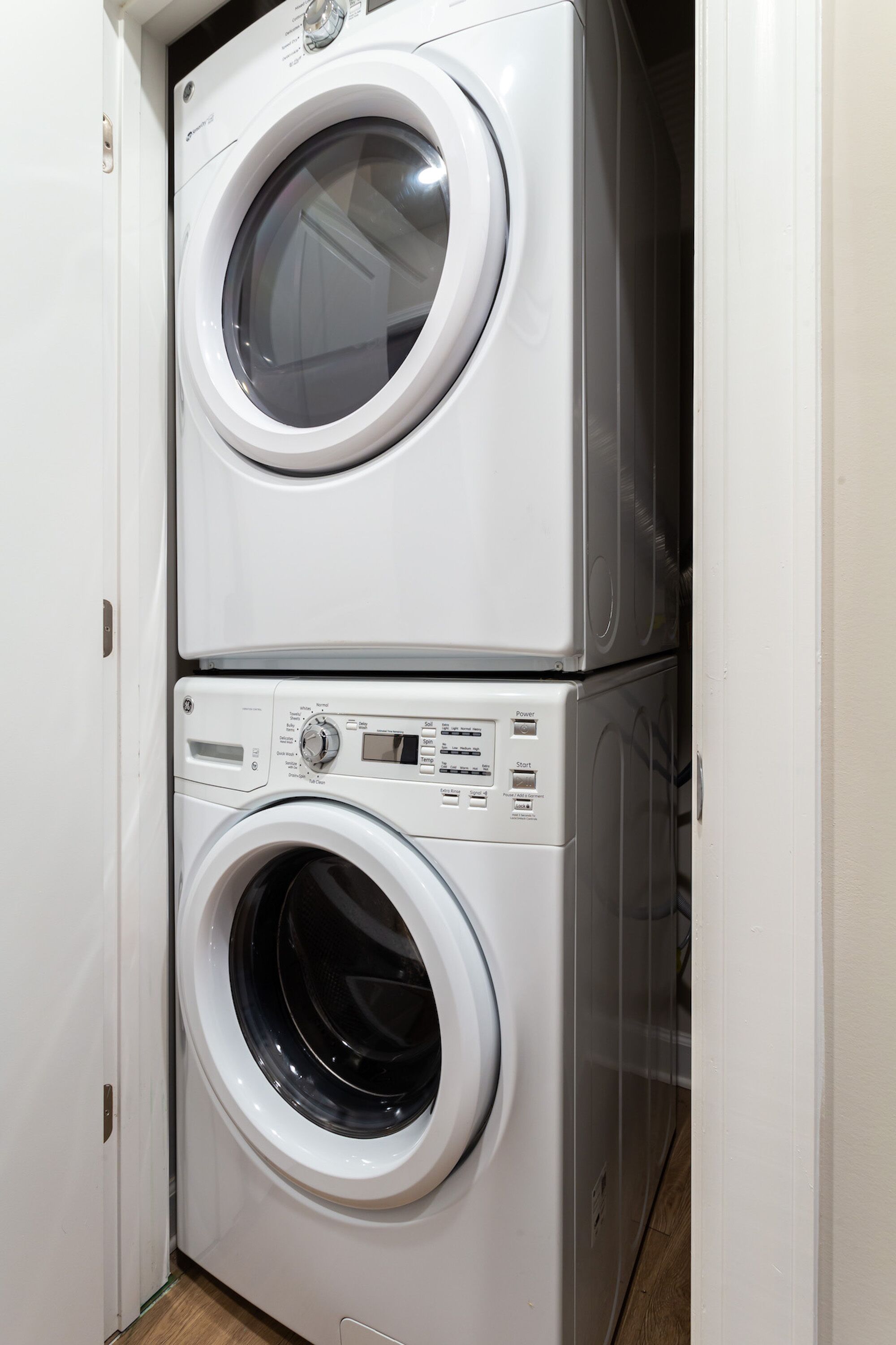A stacked washer and dryer unit in a laundry room.