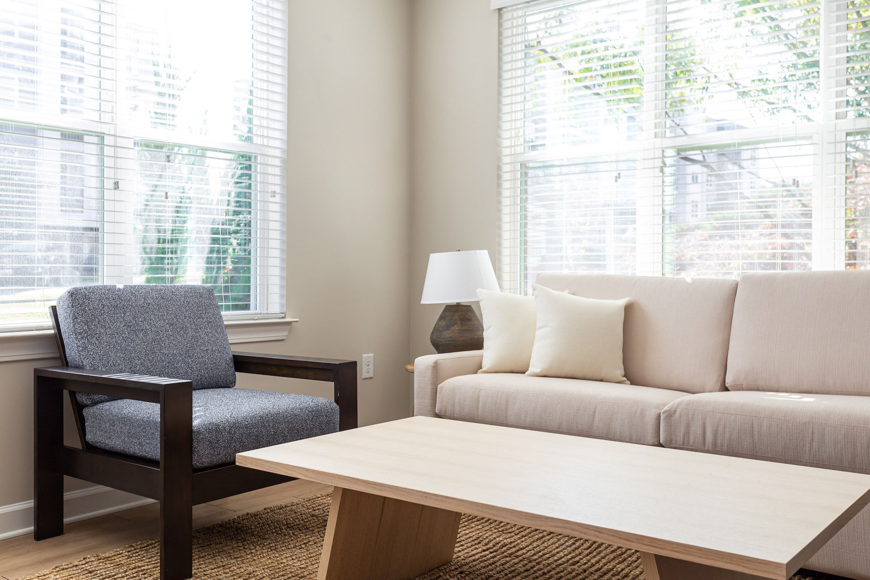 A living room with a sofa, armchair, and coffee table.