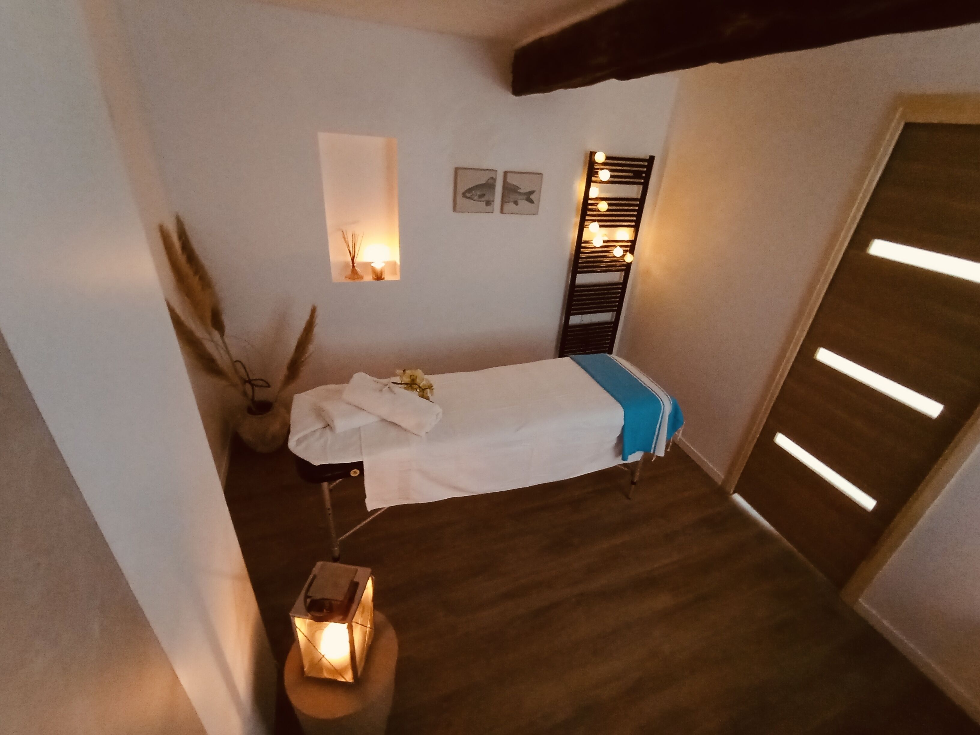 Een kleine, gezellige slaapkamer met een eenpersoonsbed, een nachtkastje, een wandplank met decoratieve objecten en een klein raam.